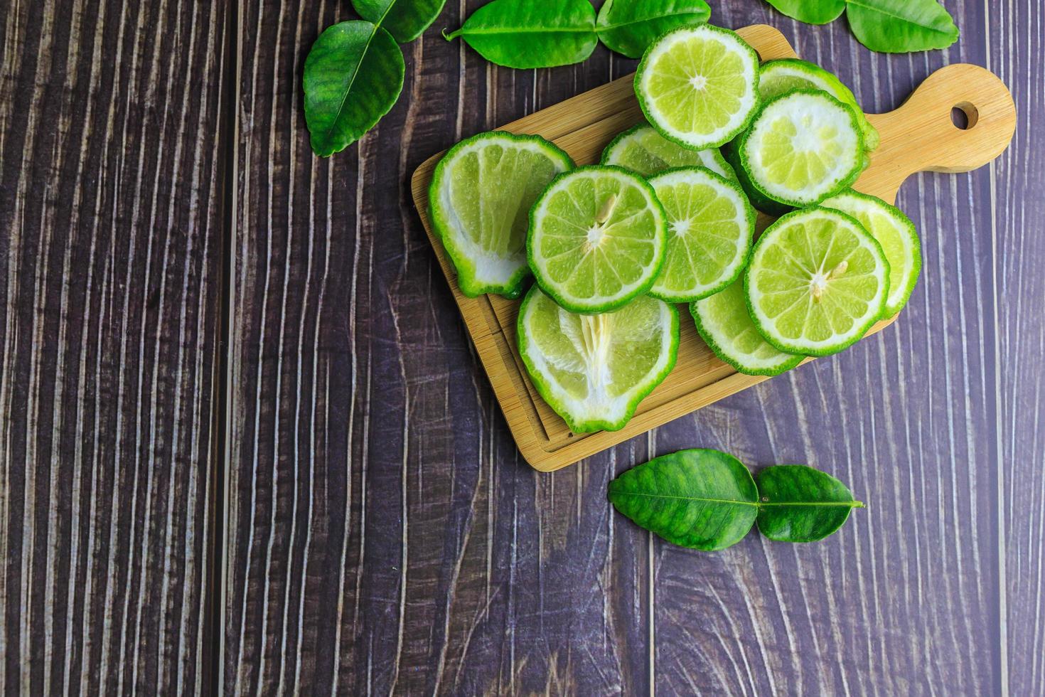 Fresh bergamot fruit slices on wooden photo