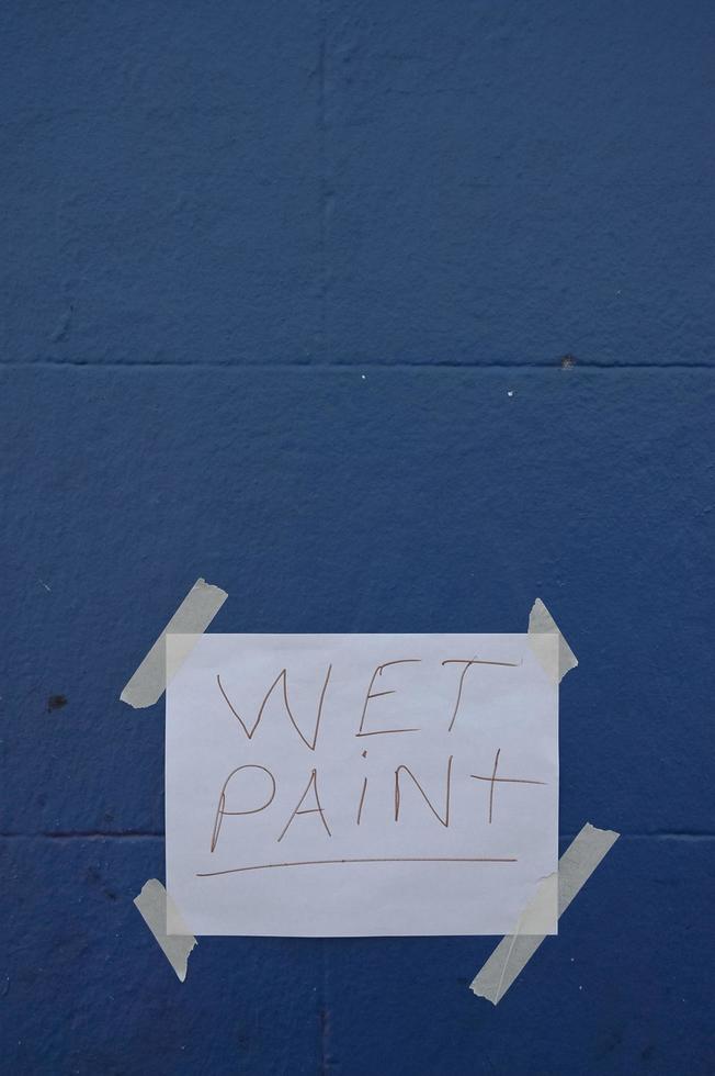 signo de papel de dolor húmedo en la pared azul foto
