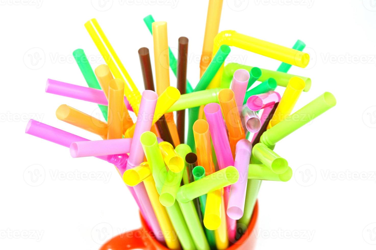 Multi-colour plastic straw tubes in an orange cup photo