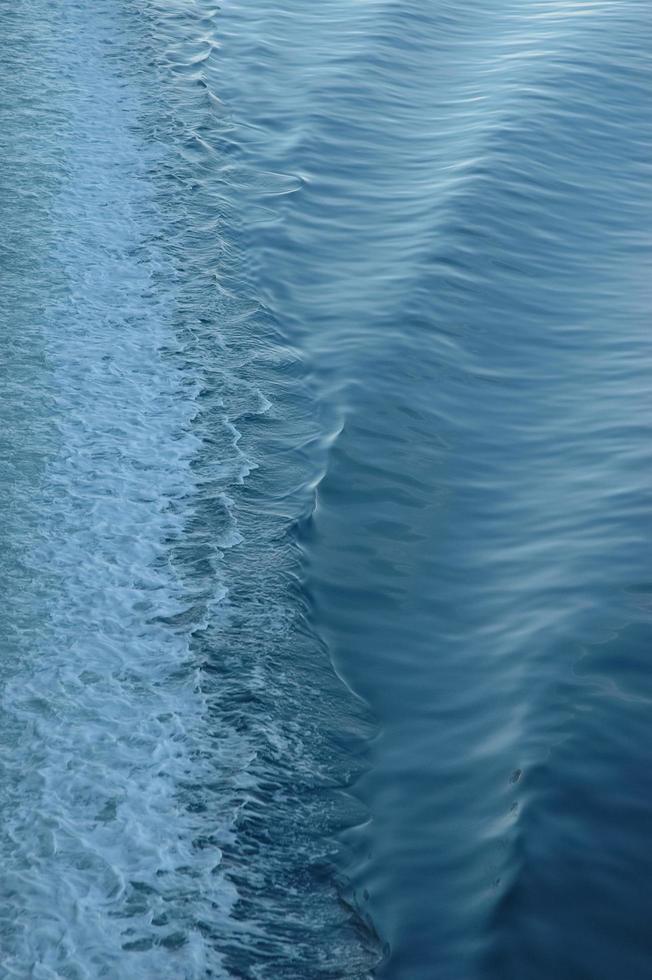 white backwash of a ferry crossing ocean photo