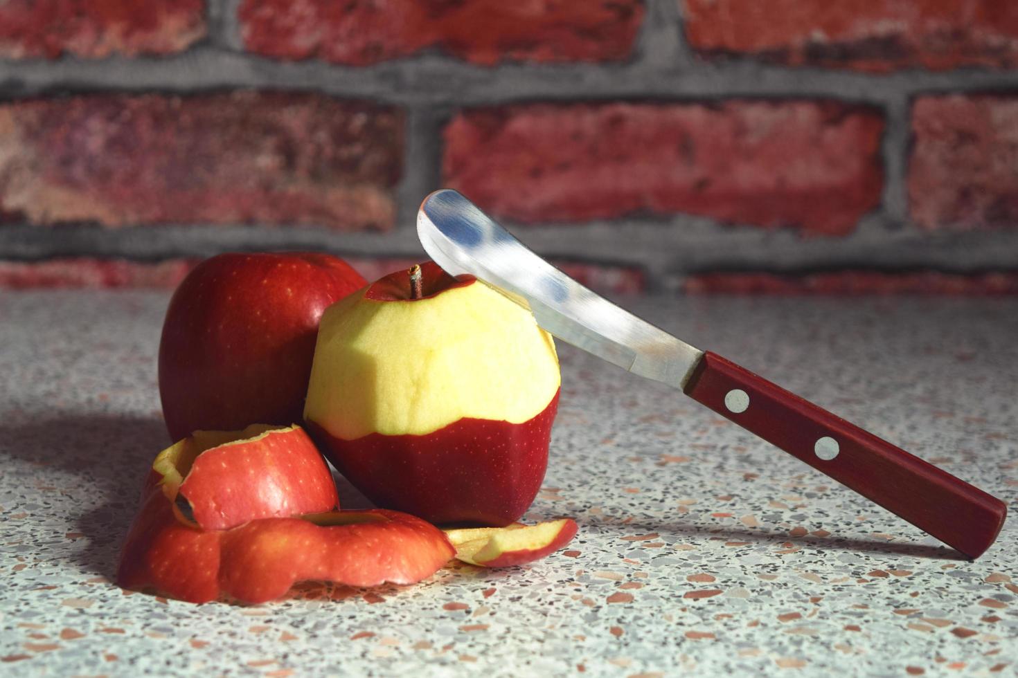 still life in crimson tones from a knife and a peeled apple photo