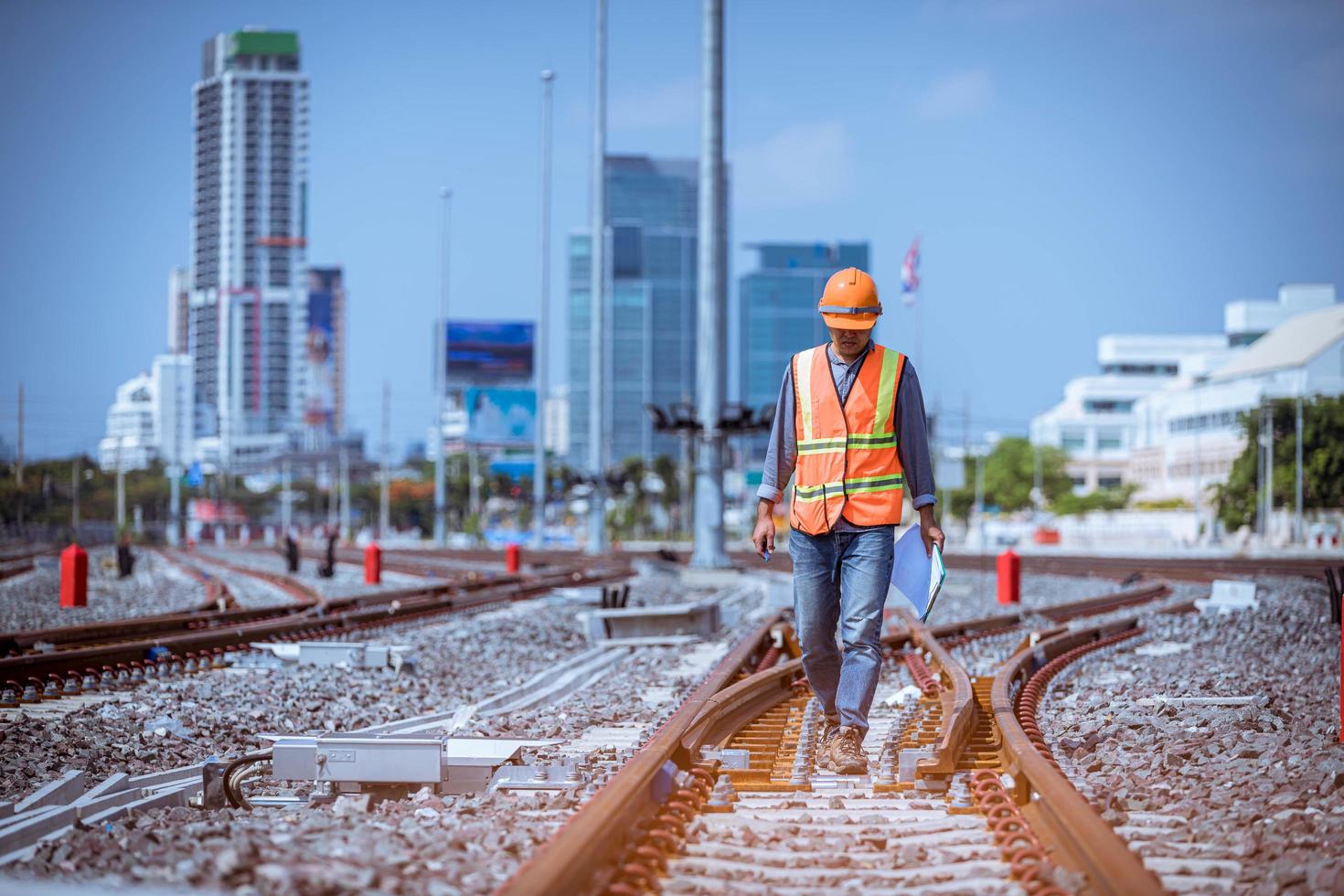 Engineer railway under  checking construction process train testing and checking railway work on railroad station with radio communication .Engineer wearing safety uniform and safety helmet in work. photo