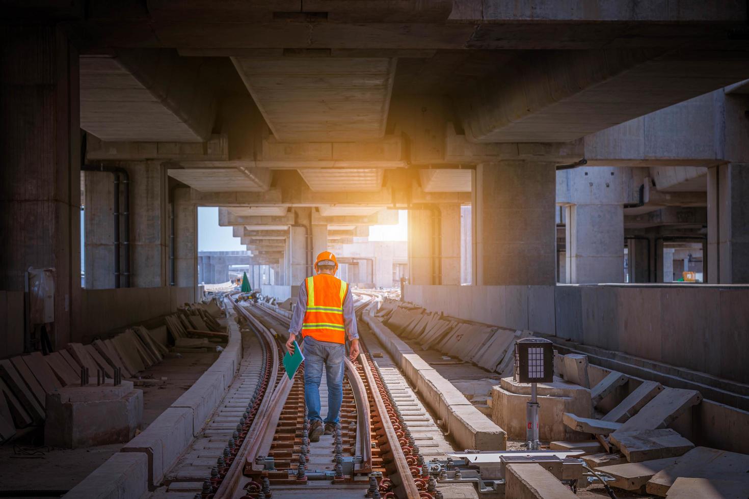 Engineer railway under  checking construction process train testing and checking railway work on railroad station with radio communication .Engineer wearing safety uniform and safety helmet in work. photo