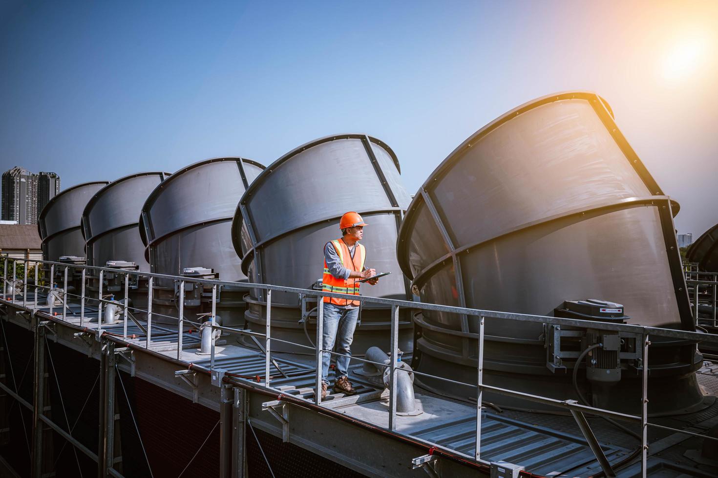 Industry engineer under checking the industry cooling tower air conditioner is water cooling tower air chiller HVAC of large industrial building to control air system. photo