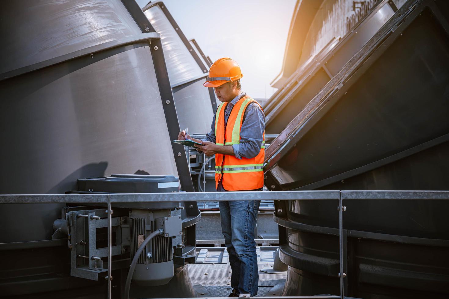 Industry engineer under checking the industry cooling tower air conditioner is water cooling tower air chiller HVAC of large industrial building to control air system. photo