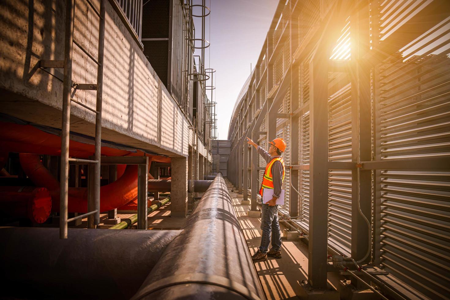 Industry engineer under checking the industry cooling tower air conditioner is water cooling tower air chiller HVAC of large industrial building to control air system. photo