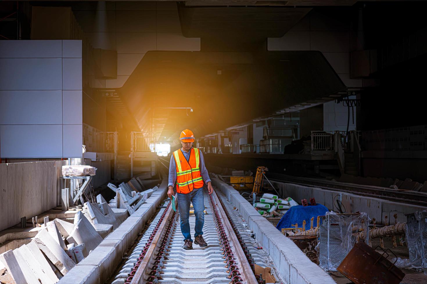 Engineer railway under  checking construction process train testing and checking railway work on railroad station with radio communication .Engineer wearing safety uniform and safety helmet in work. photo