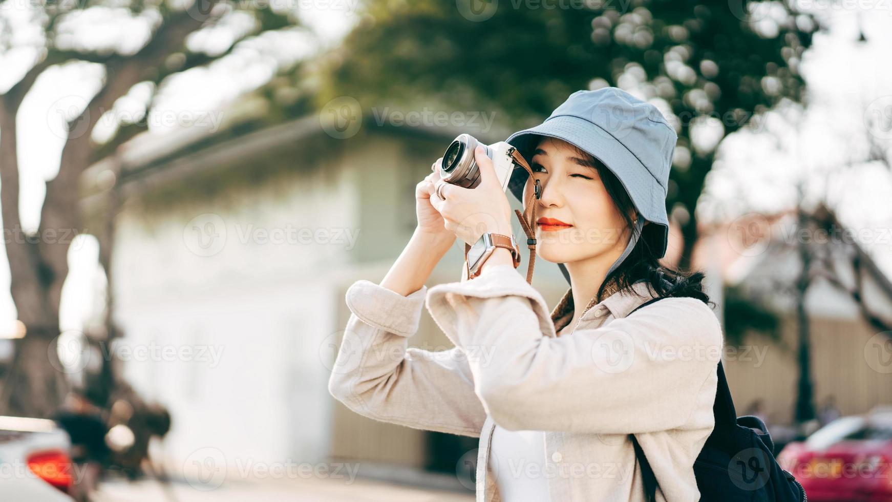 atractiva joven viajera asiática adulta usando cámara para un viaje fotográfico. foto