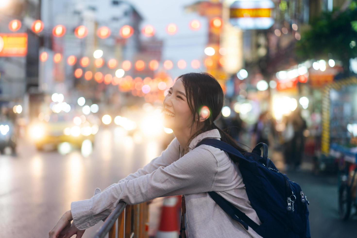 Young adult asian woman traveller backpack traveling in city lifestyle chinatown street food  with bokeh background. photo