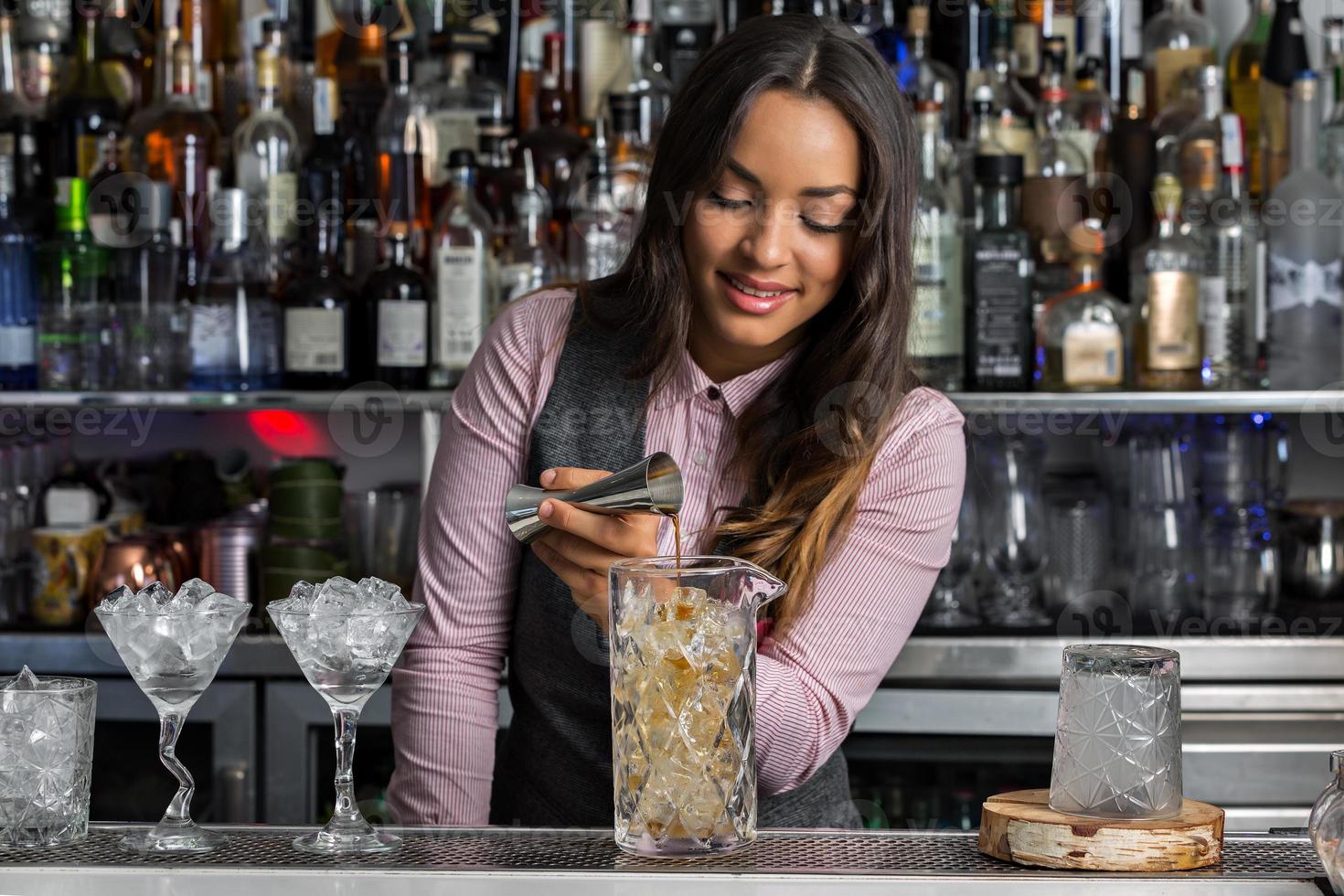 barman positiva haciendo cócteles en el bar foto