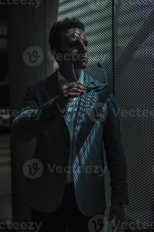 Stylish businessman with sunglasses in hand photo