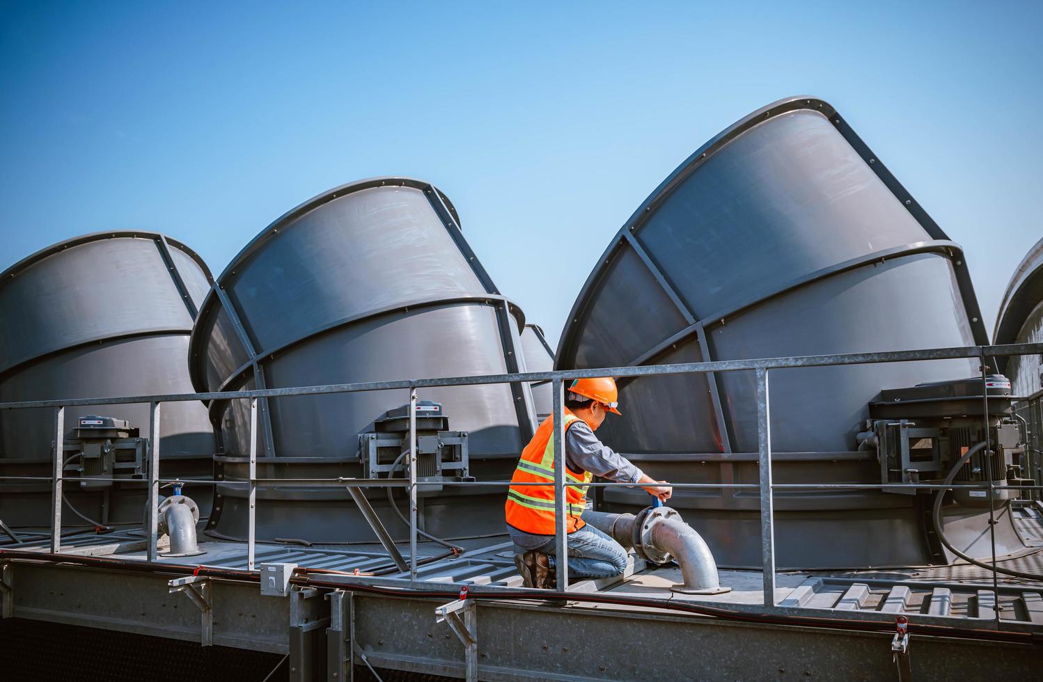 Industry engineer under checking the industry cooling tower air conditioner is water cooling tower air chiller HVAC of large industrial building to control air system. photo