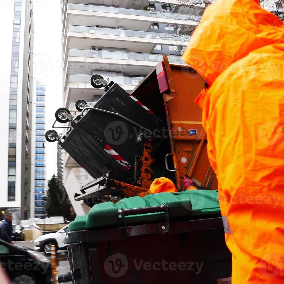 imagen borrosa de movimiento de un trabajador del servicio de limpieza vaciando el cubo de basura. foto