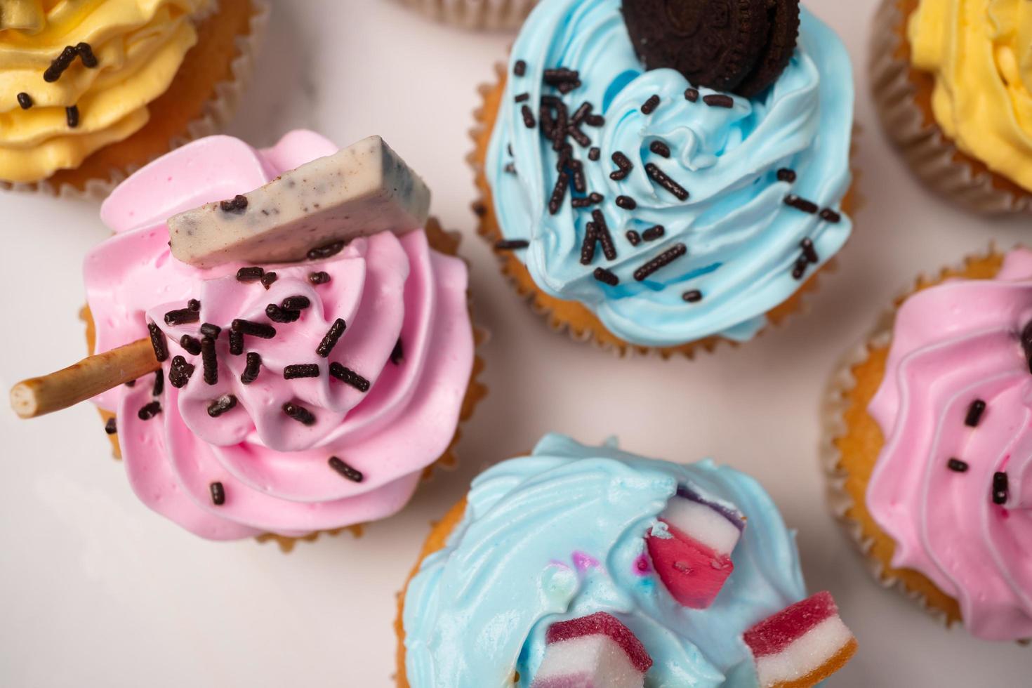 Delicious homemade cupcakes with Colorful cream and topping with candy and Chocolate Cookies. Homemade autumn holiday dessert photo