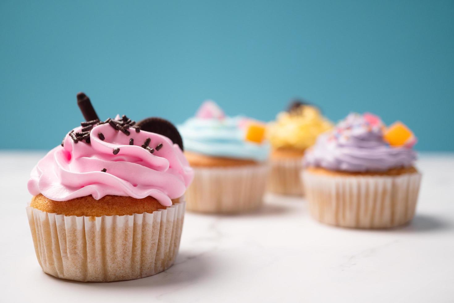 Delicious homemade cupcakes with Colorful cream and topping with candy and Chocolate Cookies. Homemade autumn holiday dessert photo