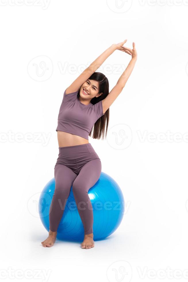 mujer asiática saludable sentada y entrenando en fitball sobre fondo blanco aislado, el concepto de buena salud comienza con el ejercicio. foto