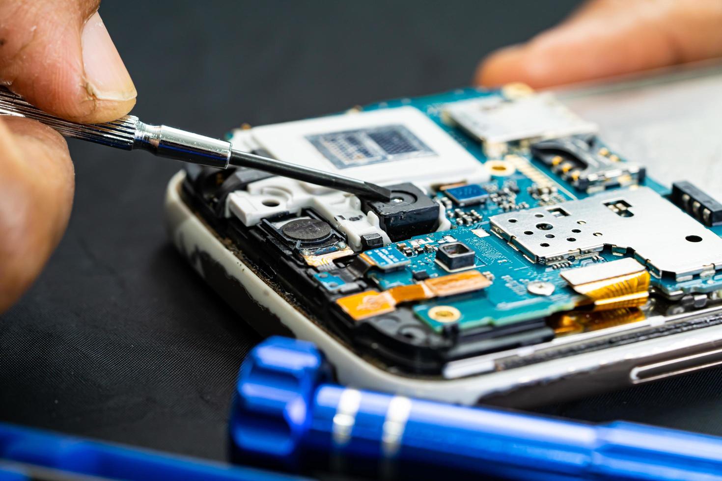 Technician repairing inside of mobile phone by soldering iron. Integrated Circuit. the concept of data, hardware, technology. photo