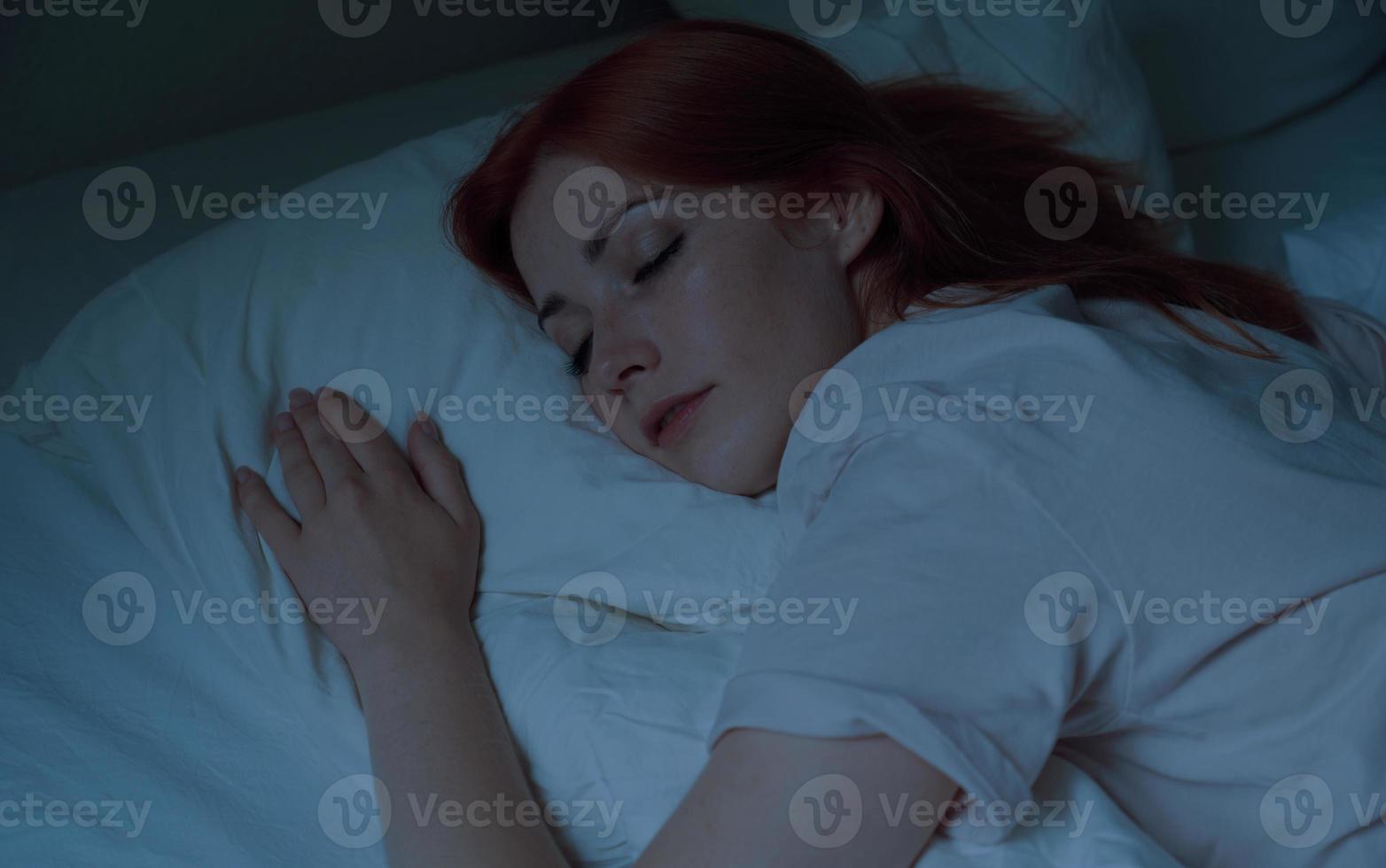 young woman asleep in bed at night photo