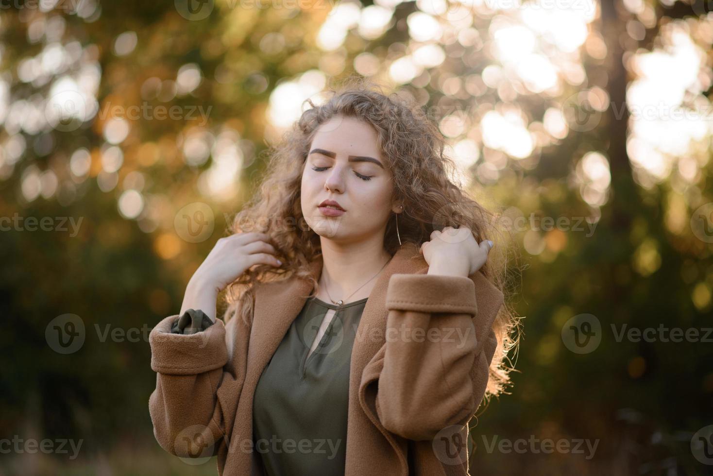 hermosa mujer elegante de pie en un parque en otoño foto