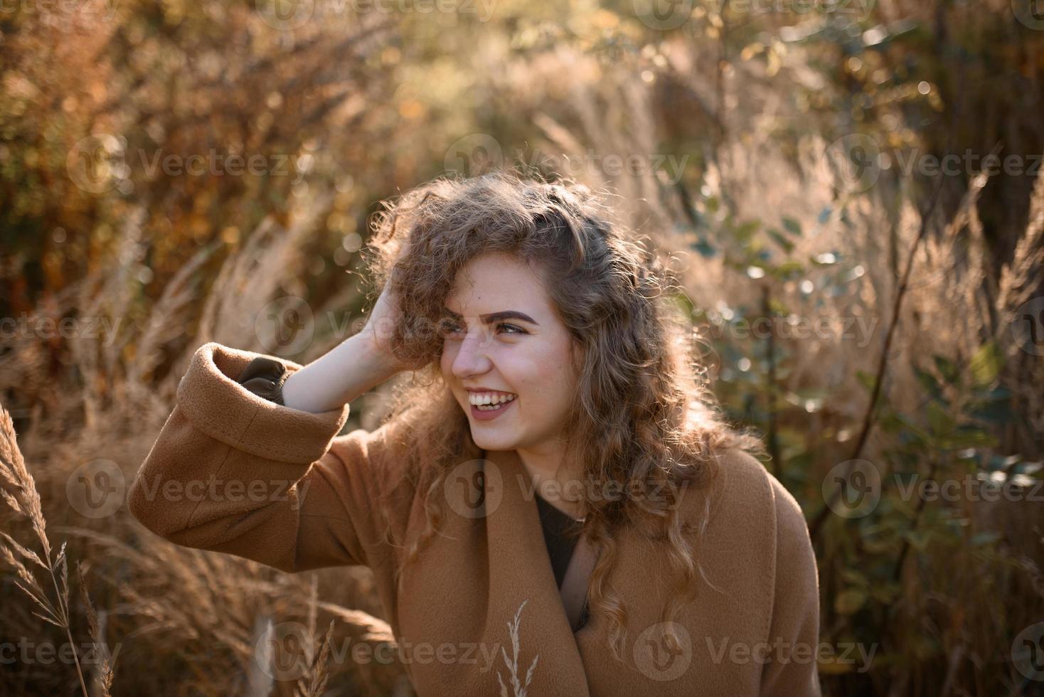 hermosa mujer elegante de pie en un parque en otoño foto