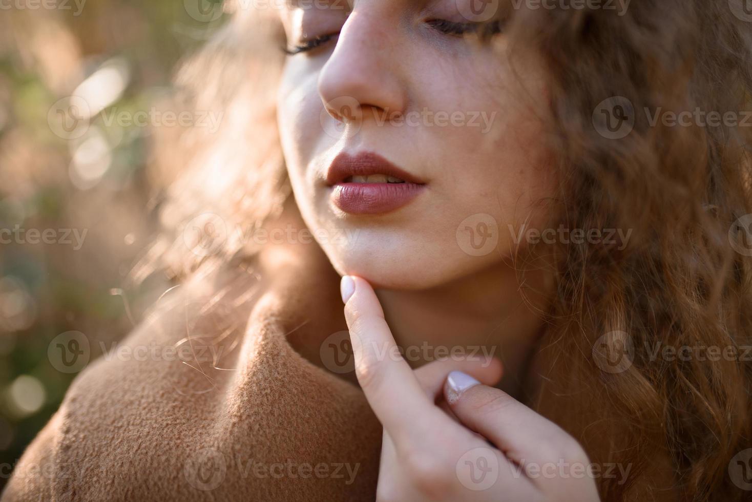 Beautiful elegant woman standing in a park in autumn photo