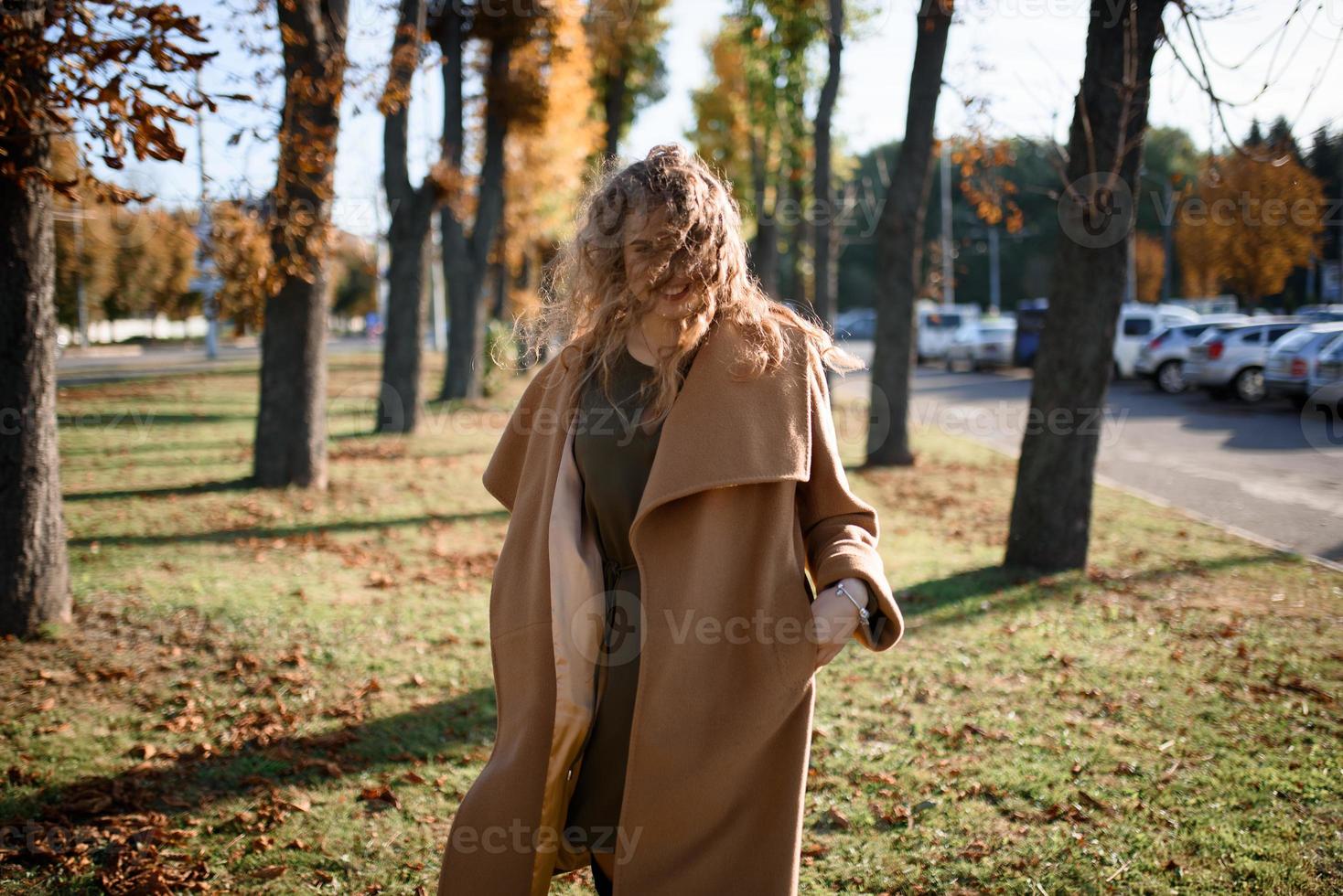 Beautiful elegant woman standing in a park in autumn photo