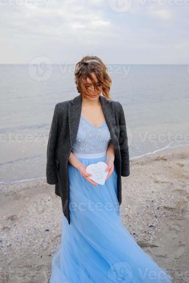 Wedding photo session of a couple on the seashore. Blue wedding dress on the bride.