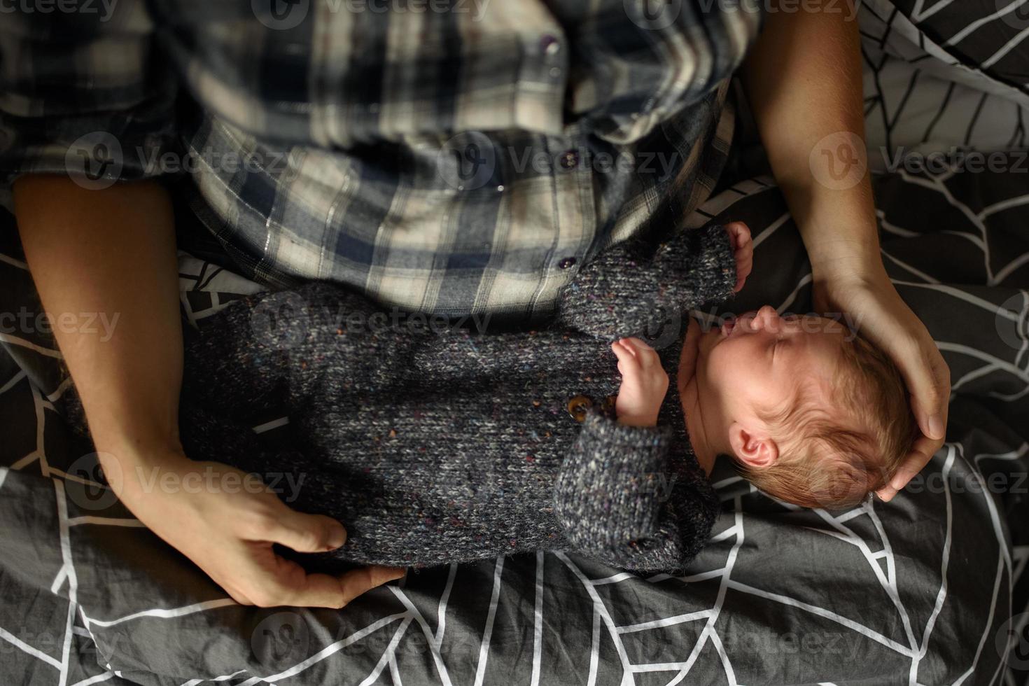 Mom holds in her arms her newborn son. photo