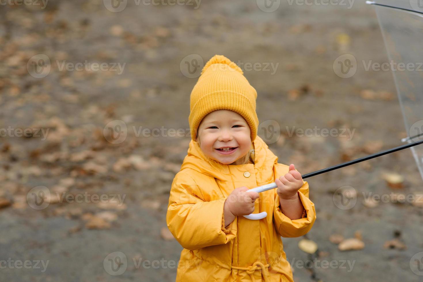 A little girl walks with an umbrella in yellow rubber boots and a  waterproof raincoat. Autumn Walk. 6676400 Stock Photo at Vecteezy