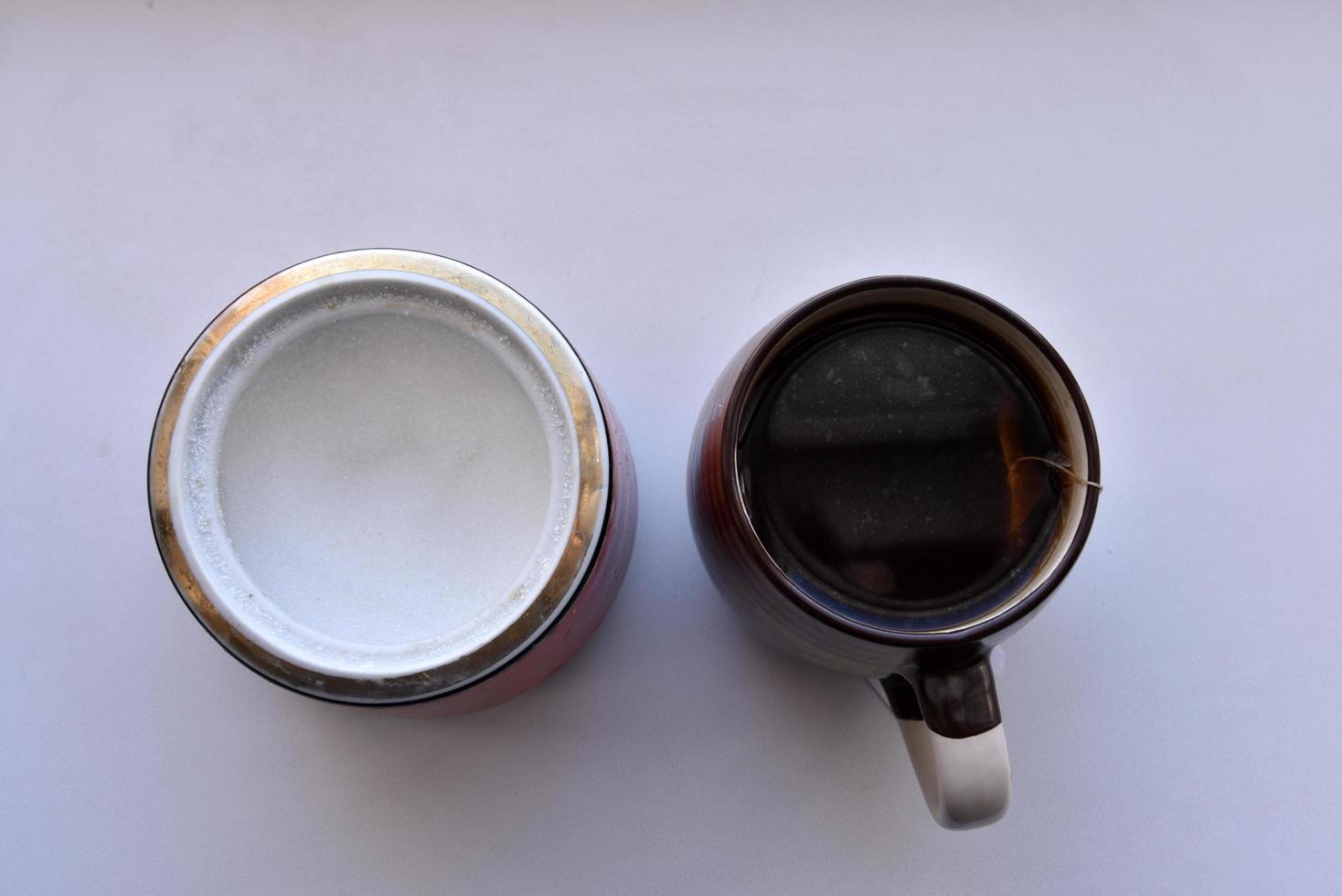Sugar bowl with a spoon and a mug of tea photo