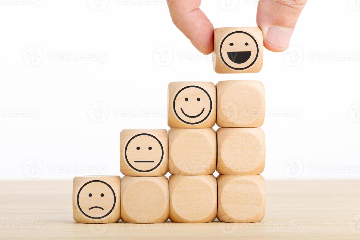 Hand chooses smiley face on wooden block. Excellent business service rating customer experience. Satisfaction survey concept photo