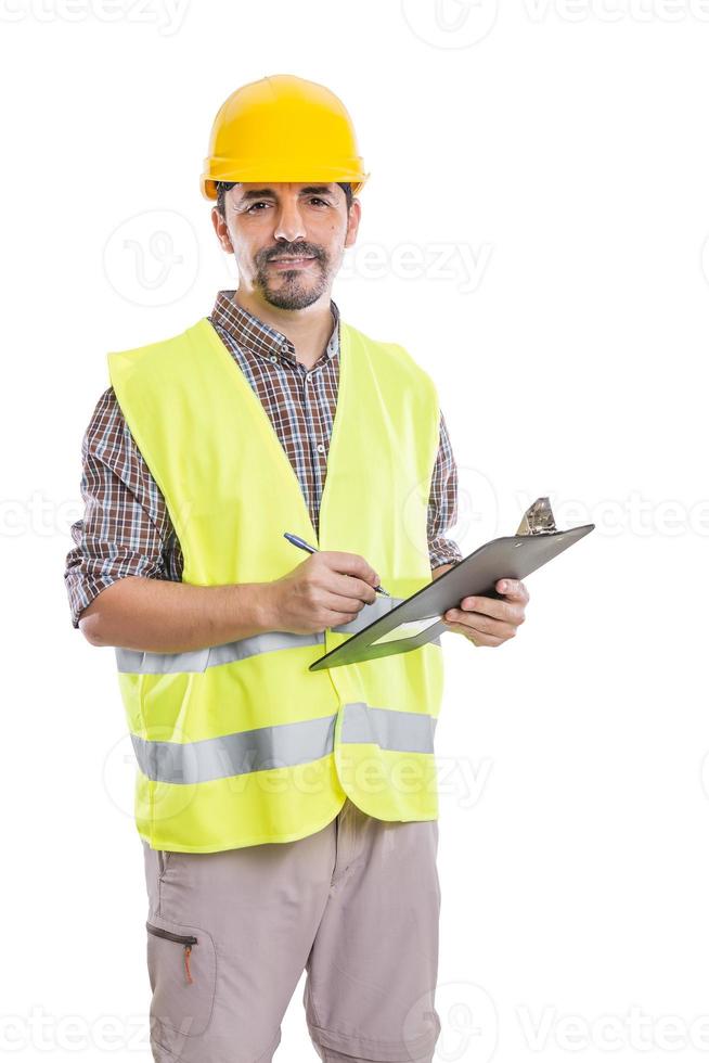 Smiling engineer taking notes on clipboard and looking at camera photo