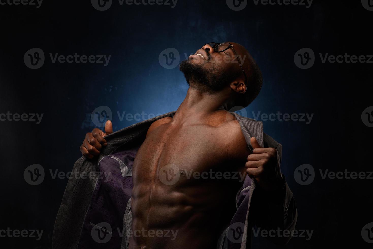 A black African American is emotionally singing into a microphone. Close-up studio portrait. photo