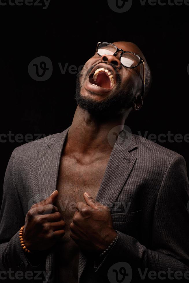 A black African American is emotionally singing into a microphone. Close-up studio portrait. photo