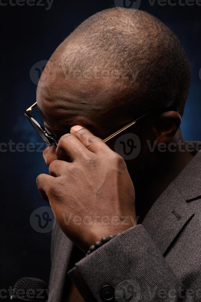 A black African American is emotionally singing into a microphone. Close-up studio portrait. photo