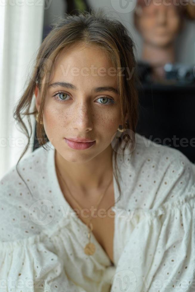 Close-up portrait of a young beautiful woman. The women looks into the frame. photo