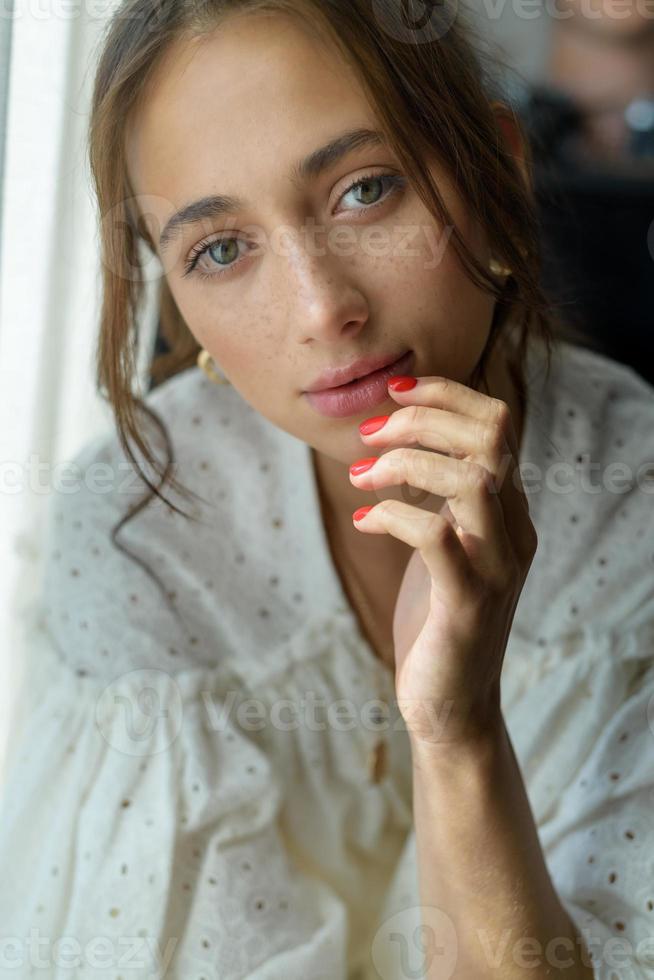 Close-up portrait of a young beautiful woman. The women looks into the frame. photo