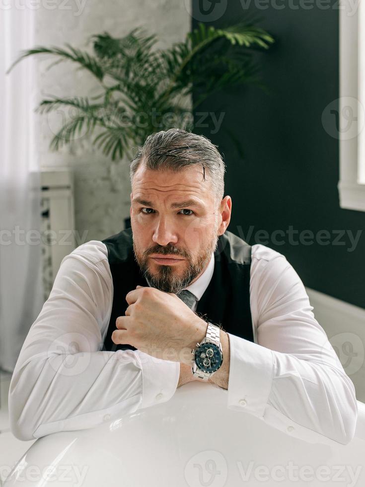 handsome mature courageous  stylish scotsman businessman in kilt and suit in bathroom. Style, work from home, fashion, lifestyle, culture, ethnic concept. photo