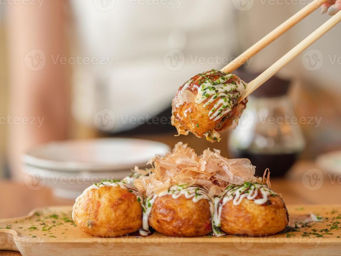 Close-up Takoyaki with chopsticks. photo
