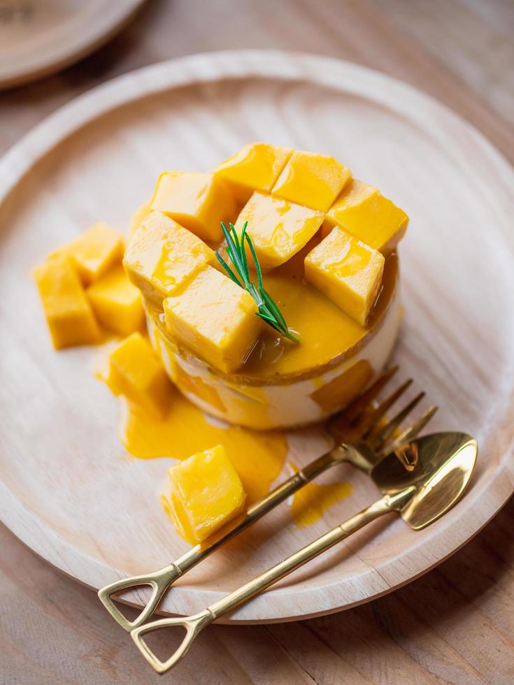 Sweet Yellow Mango Cheesecake on round wooden tray. photo