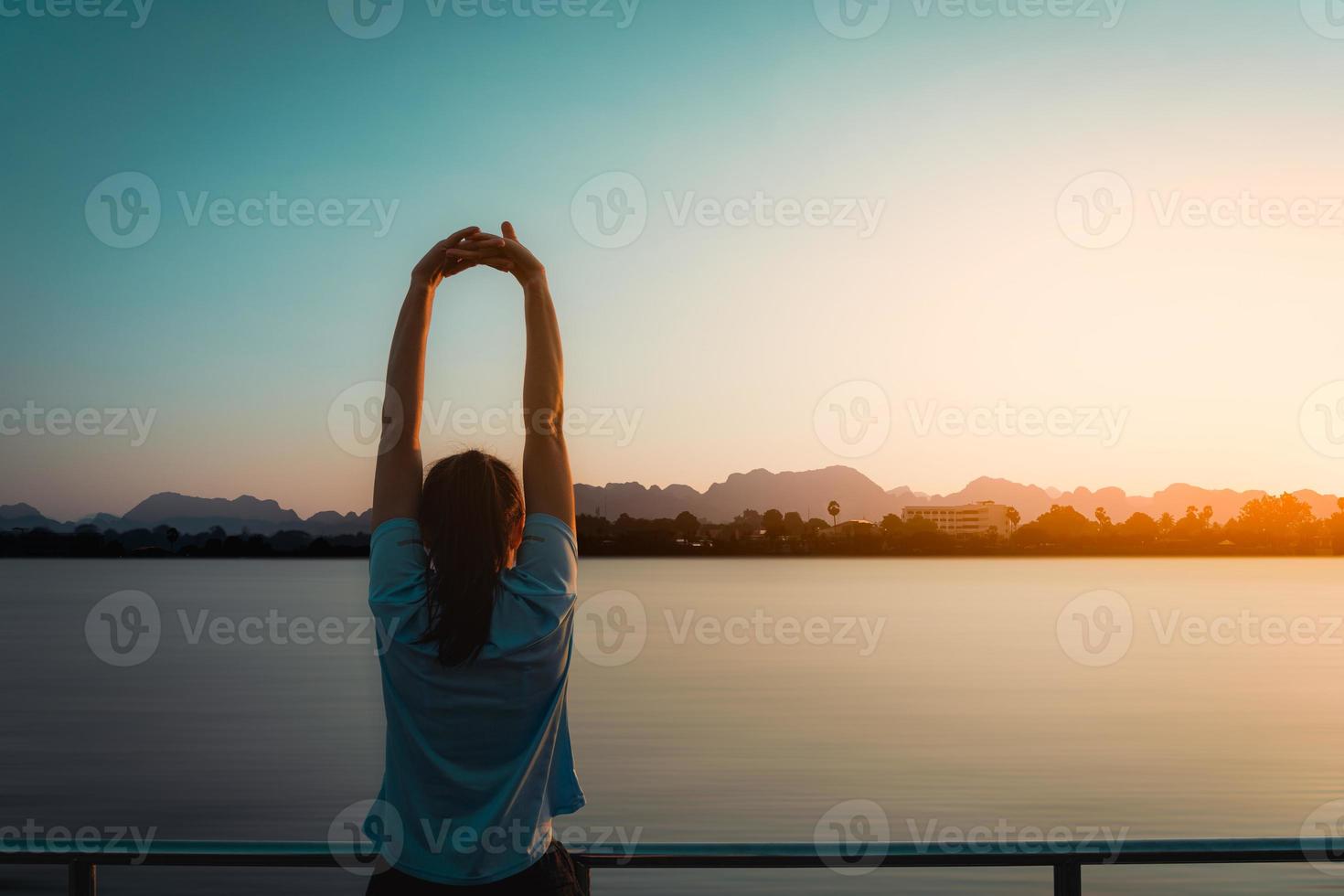 Woman is relax standing after run with a view of the river in the morning. photo