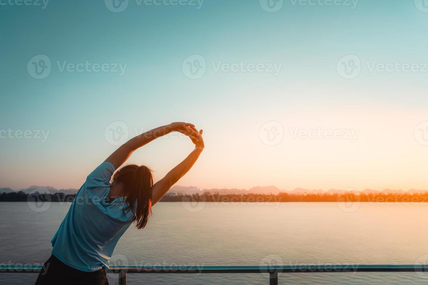 Woman is relax standing after run with a view of the river in the morning. photo