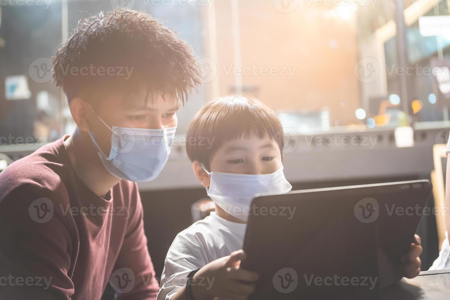 educación asiática hombre niño mirando tableta en la oficina para prepararse para la entrada del examen para aprender la lección de capacitación en línea conocimiento de la tarea digital familia de la escuela foto