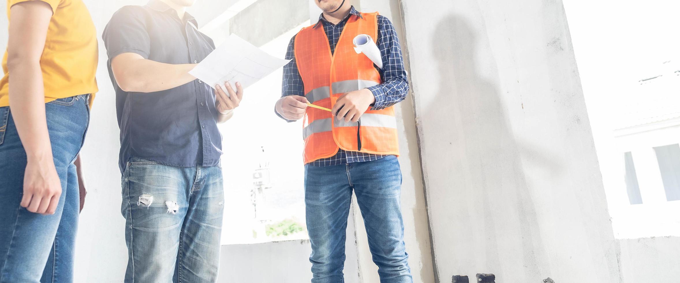 pareja asiática revisando la casa con el capataz de ingeniería inspección de la casa construcción de la casa caminar inspección de la casa con mirar y señalar la construcción para verificar la construcción de la casa en el lugar de trabajo hasta la construcción 2021 foto