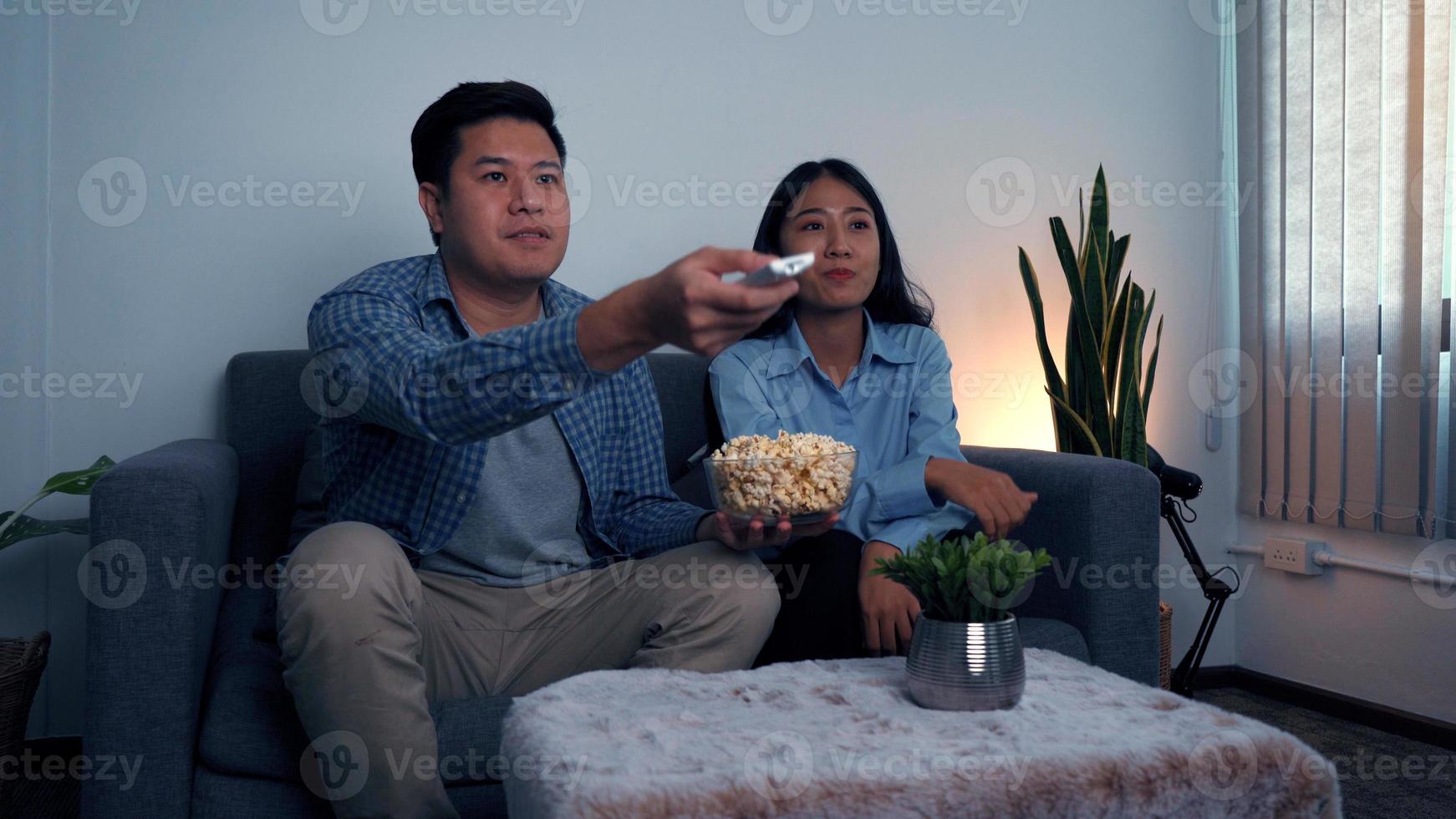 Asian couples watch movies on TV on weekends at night. photo