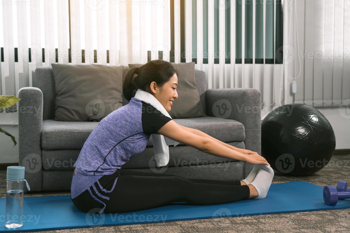 las mujeres asiáticas hacen ejercicios de estiramiento después de tomar clases de yoga en casa. foto