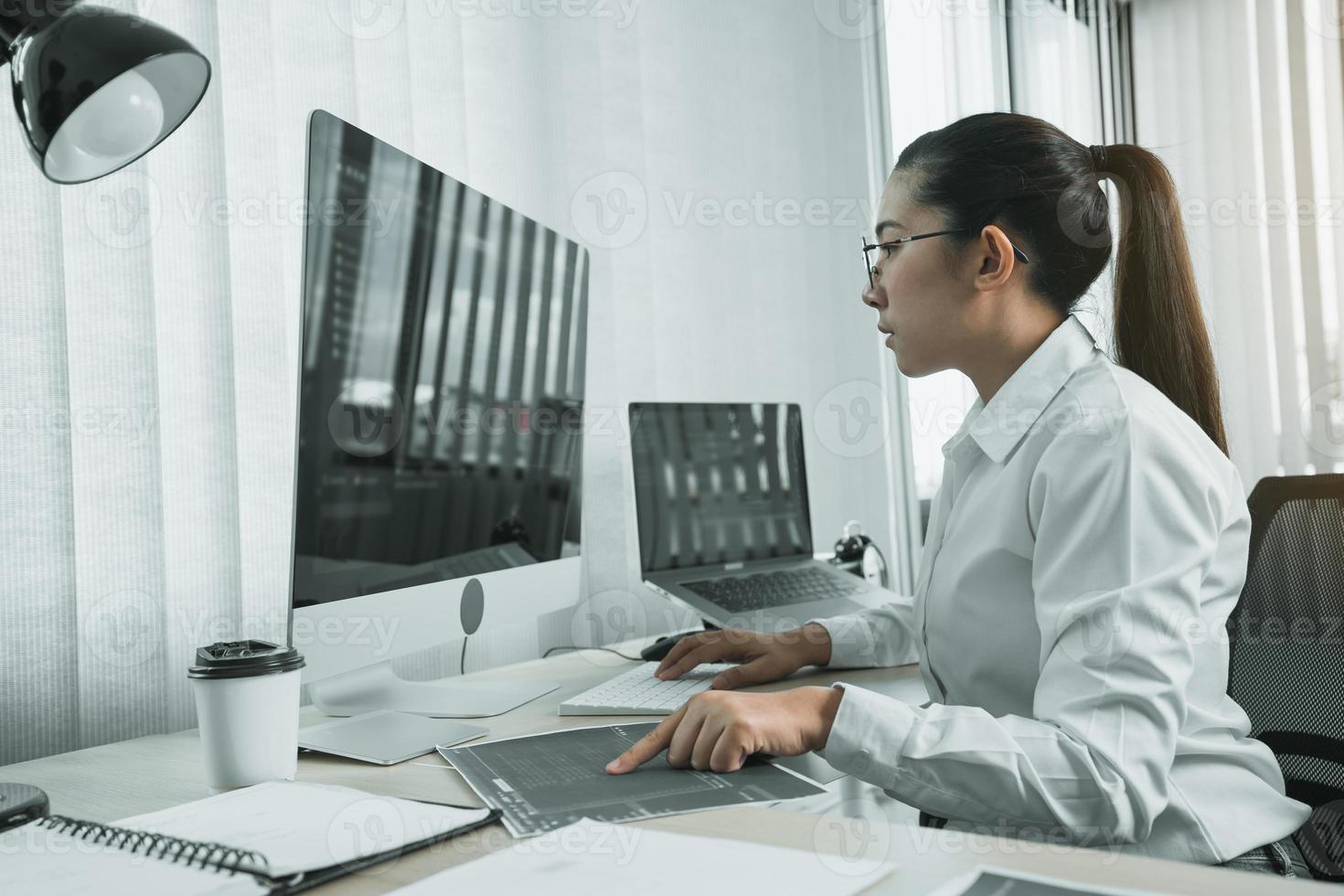 Software developers are analyzing about the code written into the program on the computer in office room. photo