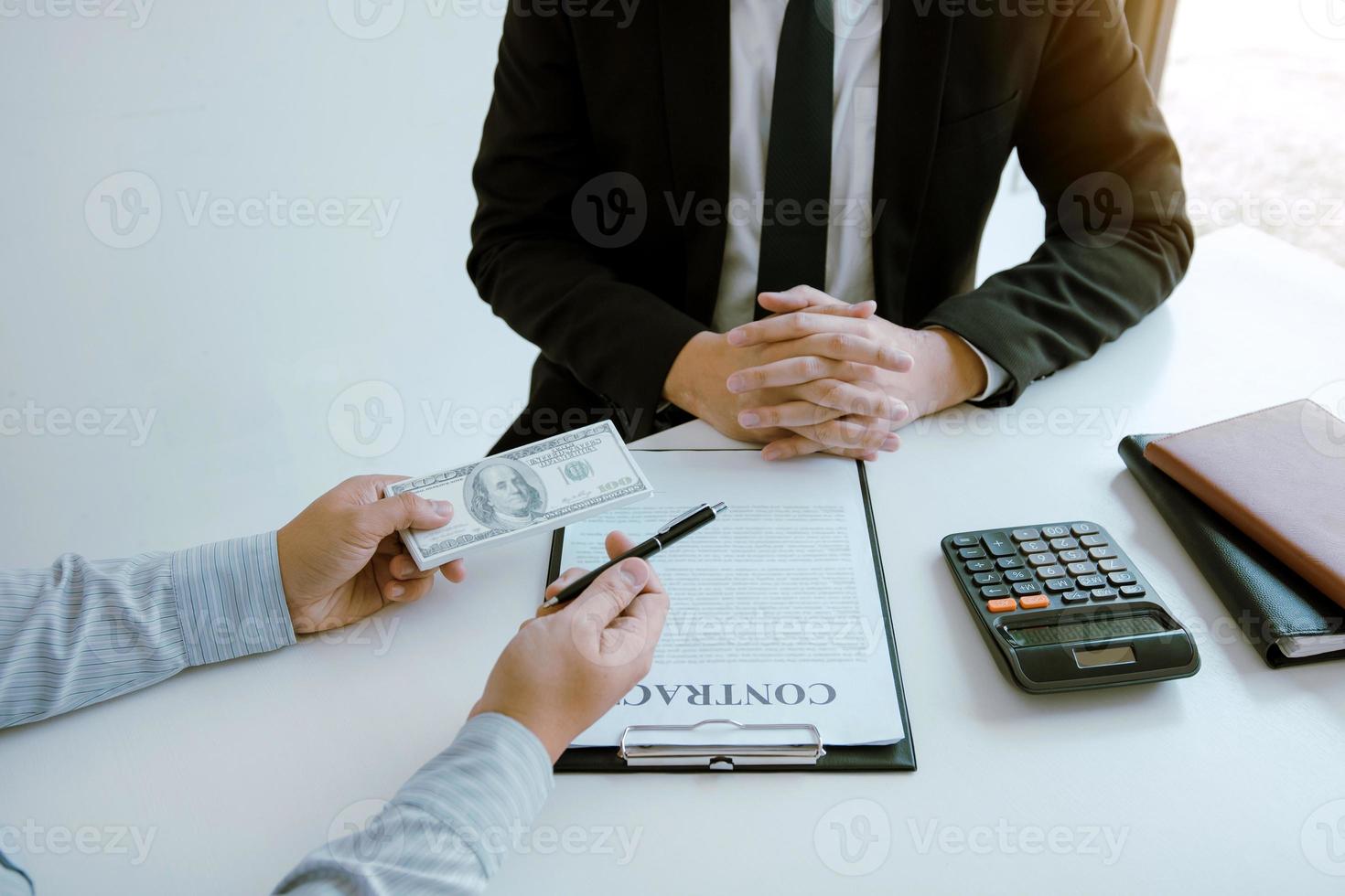 Partner has made a fraud in the contract of sale and being handed a cash and pen to the businessman signing the contract corruption bribery concept. photo