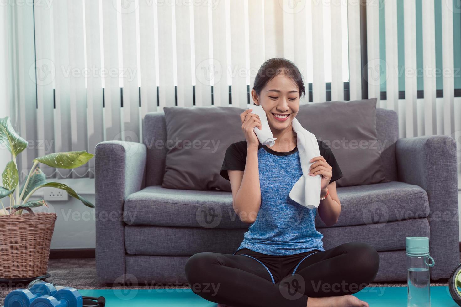 Asian women wiping their sweat away after exercising at home. photo