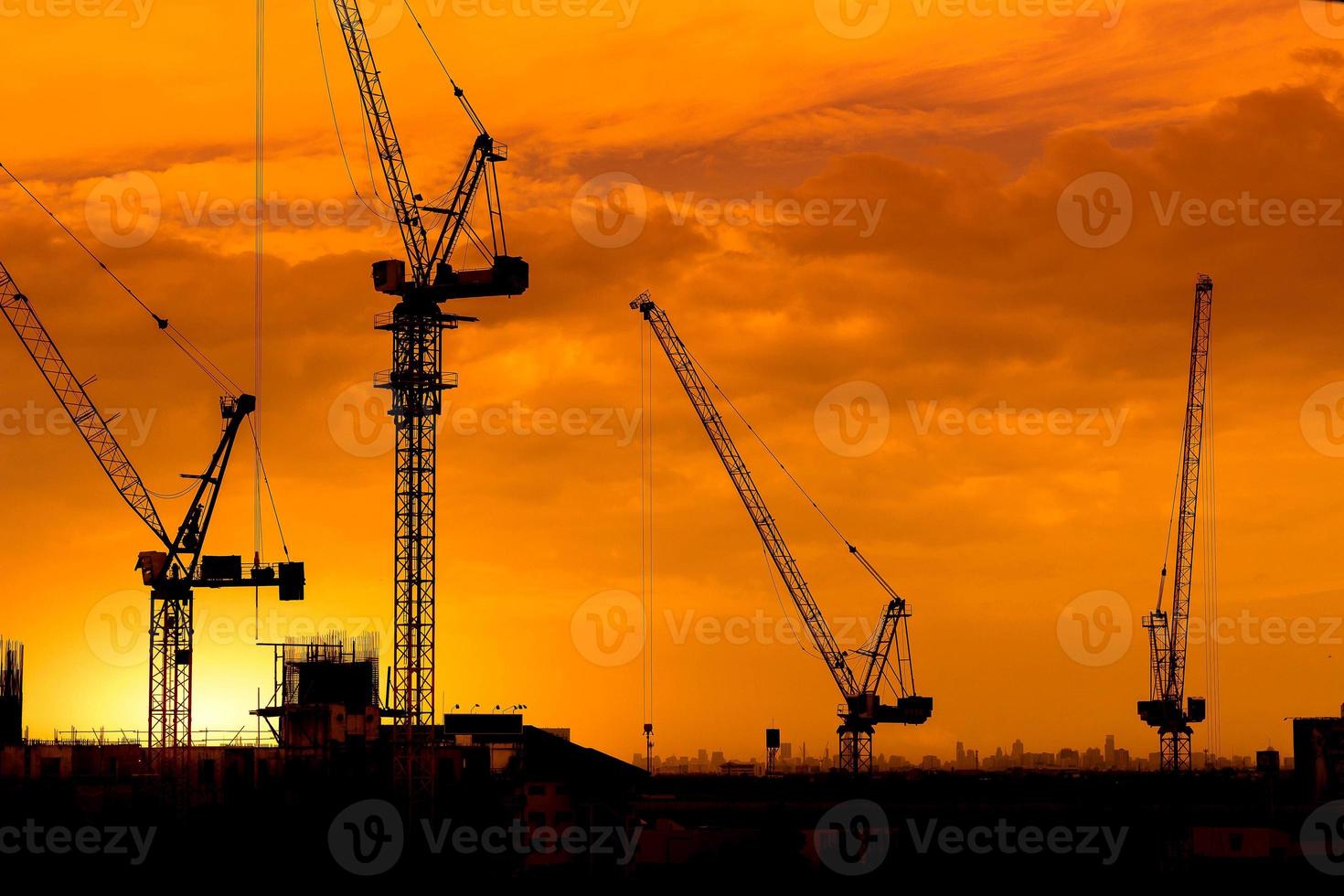 grúas de construcción y siluetas de edificios foto